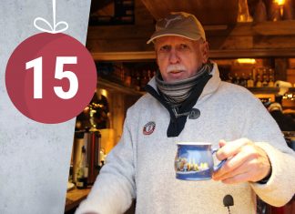 “Ich verbringe Weihnachten mit der ganzen Familie” Ein älterer Herr mit Kappe hält einen Becher Glühwein in die Kamera.