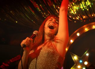 Wild Rose: Spiel mir das Lied vom Glück Protagonistin Rose (Jessie Buckley) singt auf der Bühne einer Country-Bar in Glasgow. Film: Wild Rose von Tom Harper.