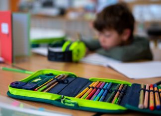 Hamburgs Grundschullehrer sollen mehr Geld bekommen Im Vordergrund ist ein Etui zu sehen, im Hintergrund ein Schulkind. Foto: Sven Hopppe/dpa