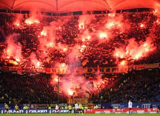 Kalte Pyrotechnik: Kühlt die Debatte endlich ab Der Auswärtsblock im Volksparkstadion ist rot erleuchtet. Fans von Dynamo Dresden haben dutzende Pyrofackeln gezündet. Foto: Christian Charisius/dpa