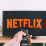 Gibt es bald Netflix-Serien aus Hamburg? Eine Fernbedienung schaltet den Fernseher an, auf dem das Netflix-Emblem erscheint. Foto: Unsplash