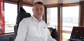 Alexander Krämer sits in the wheelhouse of a ferry in the port of Hamburg