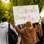 Fridays for Future: Protest gegen Siemens-Pläne Eine Frau die ein Plakat hoch hält. Darauf steht "Climate Change is real"