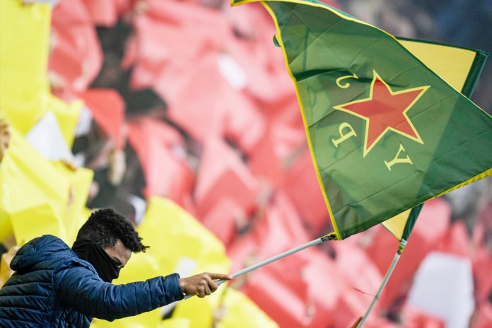 Ein FC St. Pauli Fan schwenkt eine kurdische Flagge.
