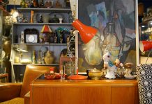 Hamburgs Trödelläden: Skurriles und Seltenes vom Spezialisten Eine alte rote Lampe steht auf einem Holzsideboard.