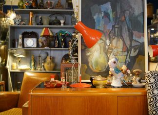 Hamburgs Trödelläden: Skurriles und Seltenes vom Spezialisten Eine alte rote Lampe steht auf einem Holzsideboard.