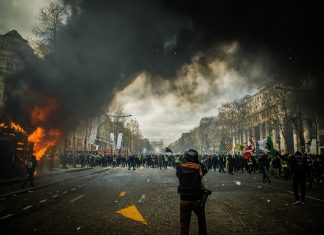 Kehrtwende der Grünen beim Vermummungsverbot? Diskussion um das Vermummungsverbot, Bild einer Demonstration: Vermummte Personen und eine brennende Mülltonne.