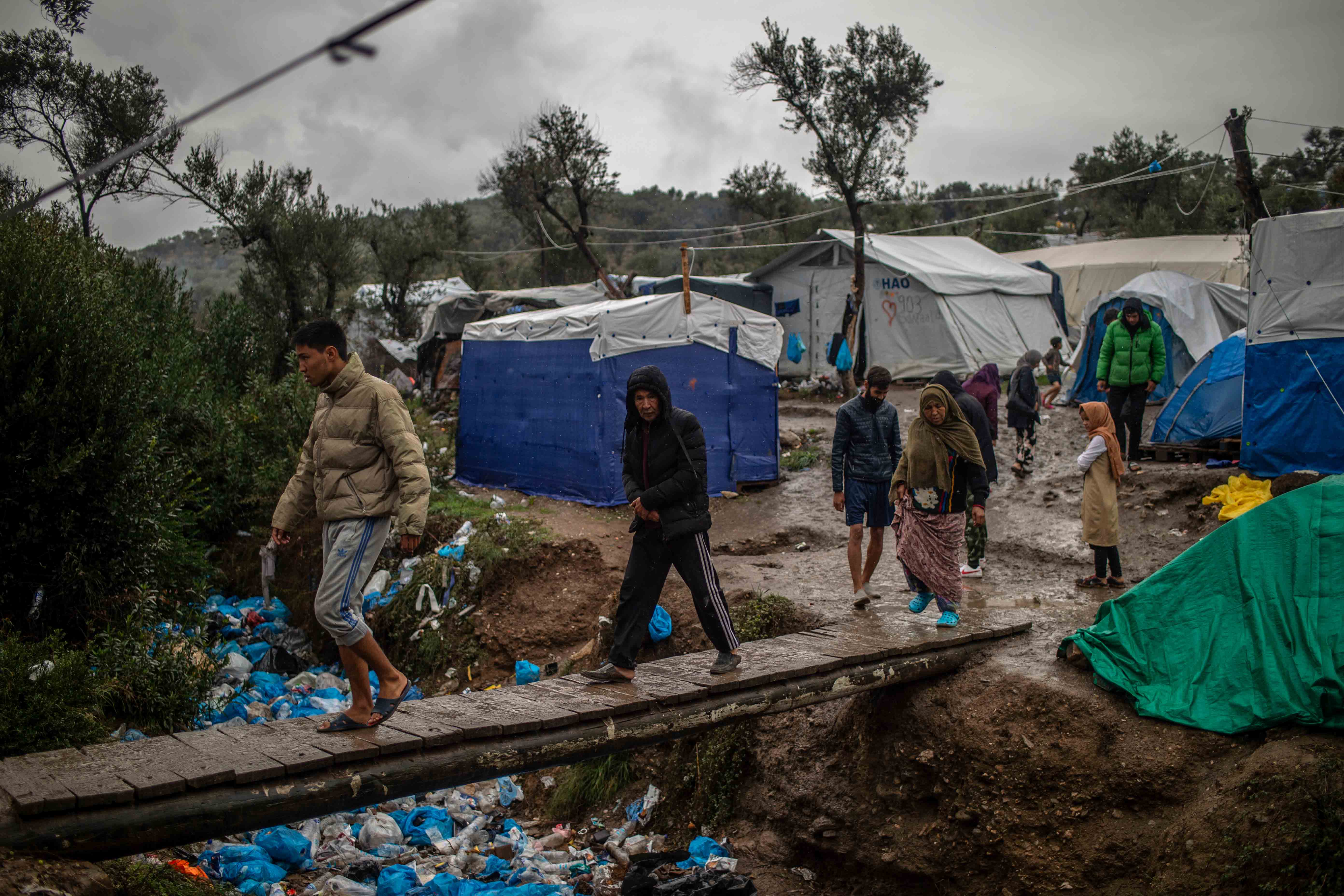 Migranten überqueren eine Holzbrücke in einem Zwischenlager neben dem Lager Moria auf der Insel Lesbos.