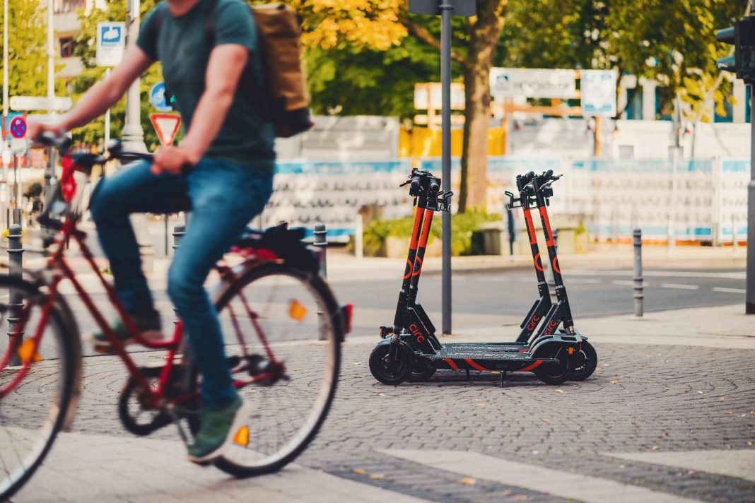E-Scooter und Fahrradfahrer auf öffentlichem Platz