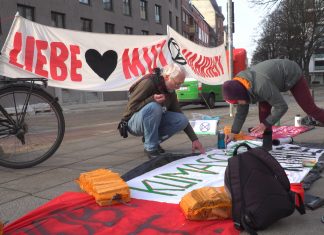 Extinction Rebellion protestiert vor Siemens Gebäude Zwei Menschen bemalen einen Banner vor dem Siemens-Gebäude in Hamburg.