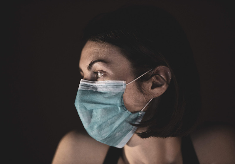 Eine Frau mit Gesichtsmaske im Profil