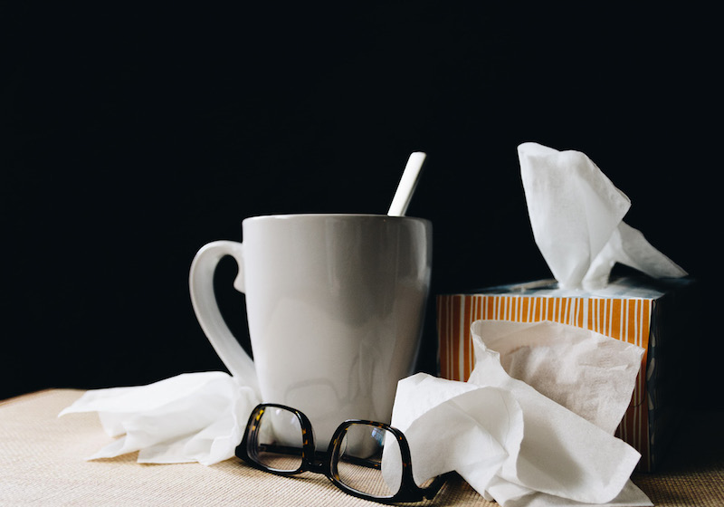Auf einem Tisch stehen eine Teetasse und eine Box mit Taschentüchern