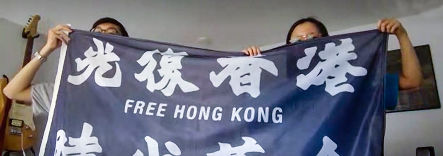 Bo (links) und Lian (rechts) mit einer Flagge der Hongkonger Demokratiebewegung. Sie sprechen über die Proteste in Hongkong und Hamburg. Foto: Pia Röpke.