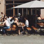 Hamburgs schönste Cafés und Restaurants zum Draußensitzen Menschen auf Bänken vor einer Bar/Restaurant