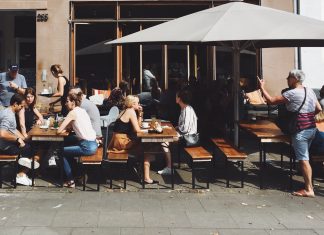 Hamburgs schönste Cafés und Restaurants zum Draußensitzen Menschen auf Bänken vor einer Bar/Restaurant