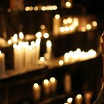 close-up-photograph-of-person-praying-in-front-lined-candles-1024900