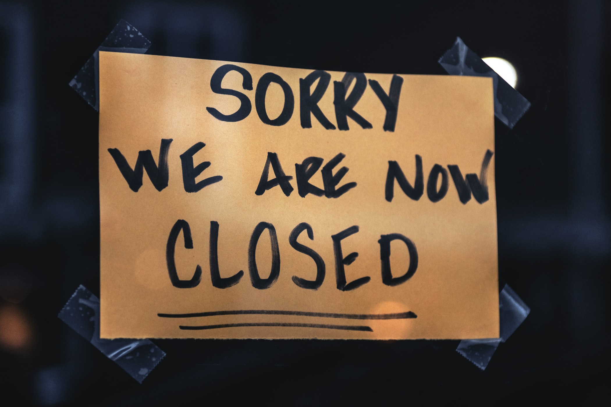 Ein Schild mit der Aufschrift: "Sorry, we are now closed" klebt an einer Scheibe.