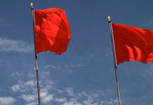 Zwei Parteien, zwei Perspektiven: Sozialismus in den USA Die USA und der Sozialismus: Drei rote Fahnen vor blauem Himmel