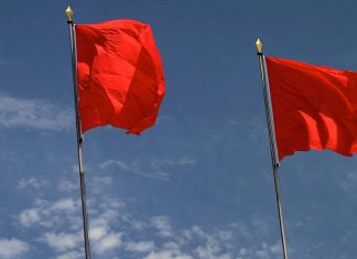 Zwei Parteien, zwei Perspektiven: Sozialismus in den USA Die USA und der Sozialismus: Drei rote Fahnen vor blauem Himmel