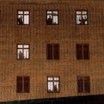 Corona in Gefängnissen: Keine Haft für Kleinkriminelle Ein Gefängnis von aßen. Hinter den vergitterten Fenstern Schatten von Insassen.