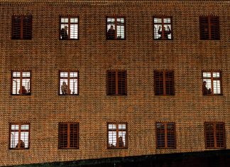 Corona in Gefängnissen: Keine Haft für Kleinkriminelle Ein Gefängnis von aßen. Hinter den vergitterten Fenstern Schatten von Insassen.