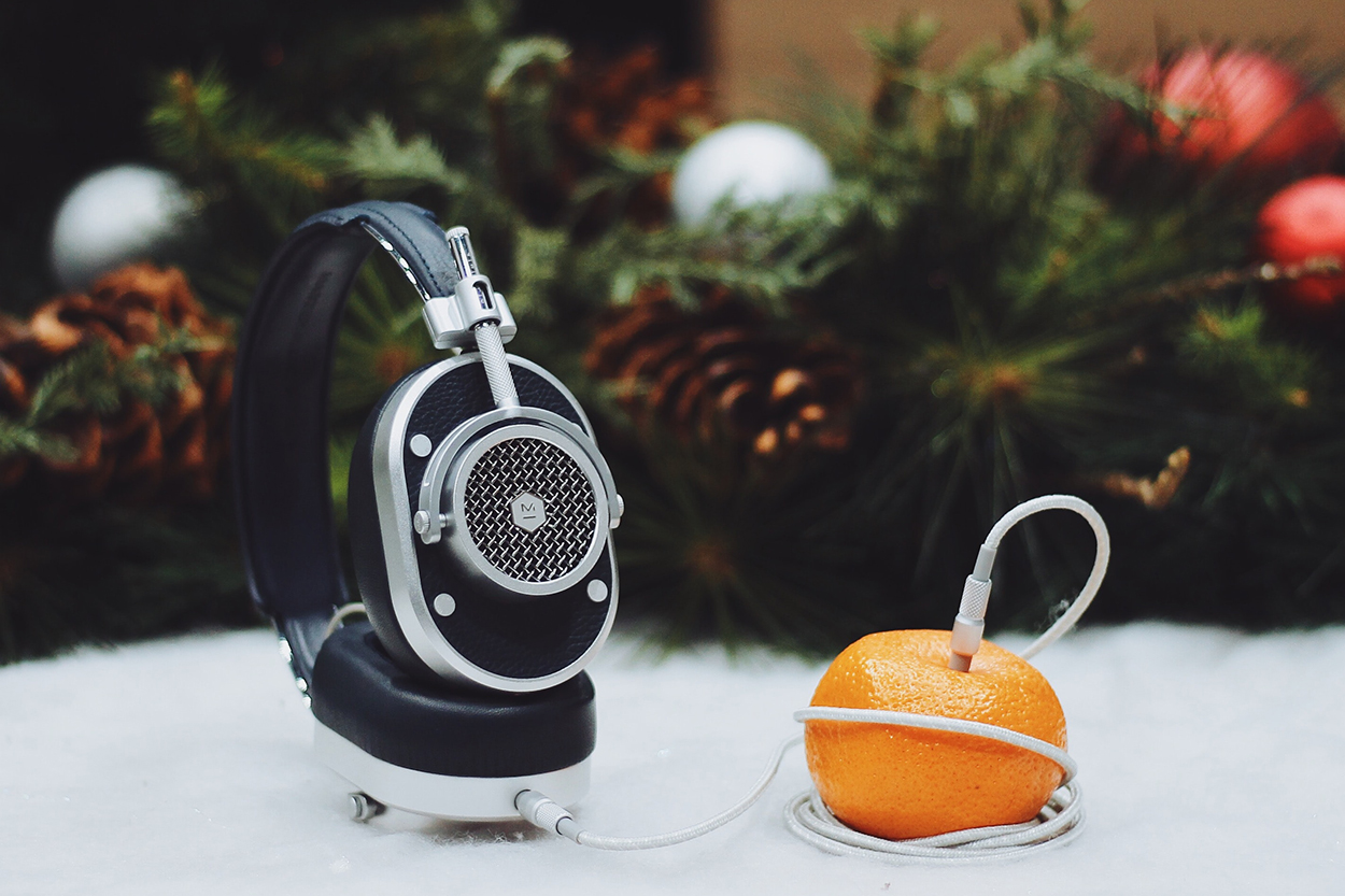 Ein Kopfhörer steckt in einer Orange und steht symbolisch für Weihnachtslieder