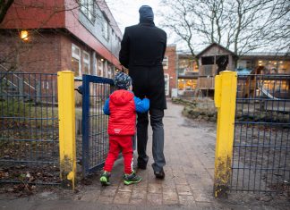 Ab Montag in Kitas nur noch Notbetreuung Ein Vater begleitet sein Kind auf das Gelände einer Kita.