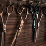 Klage eingereicht: Friseurbetriebe wollen wieder öffnen Friseurscheren hängen an Wand,