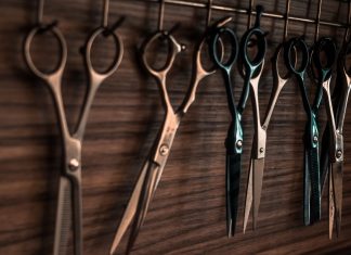 Klage eingereicht: Friseurbetriebe wollen wieder öffnen Friseurscheren hängen an Wand,