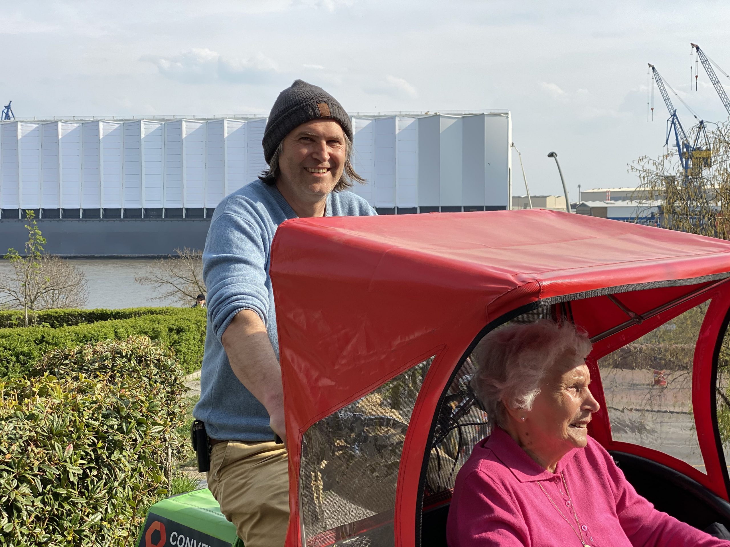 Marko Schier fährt die 93-Jährige Marta Bartsch in einer Rikscha am Hamburger Hafen