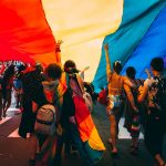 Hamburg setzt Zeichen gegen Homo-, Bi-, Inter- und Transfeindlichkeit Menschen unter einer Prideflagge