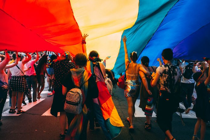 Menschen unter einer Prideflagge