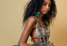 Revolutioniert Bioplastik die Textilindustrie? Frau trägt große, kreisförmige Ohrringe mit grüner Fläche. Ein Oberteil aus weißem Bioplastik und eine Tasche mit Elementen aus Bioplastik.