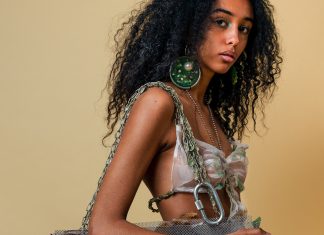 Revolutioniert Bioplastik die Textilindustrie? Frau trägt große, kreisförmige Ohrringe mit grüner Fläche. Ein Oberteil aus weißem Bioplastik und eine Tasche mit Elementen aus Bioplastik.