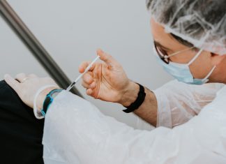 Gesundheitssenatorin ruft zur Booster-Impfung auf Ein Arzt impft einen Patienten. Booster