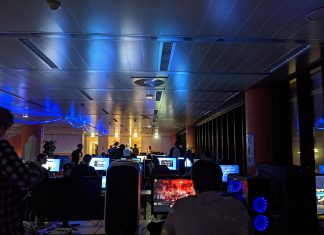 Bis die Kabeltrommeln überhitzen: LAN-Party in der Hochschule HAW LAN-Party 2021 am Berliner Tor. Der Raum ist dunkel und beleuchtet mit Neon-Lichtern. Einige Menschen sitzen vor PCs und spielen Videospiele