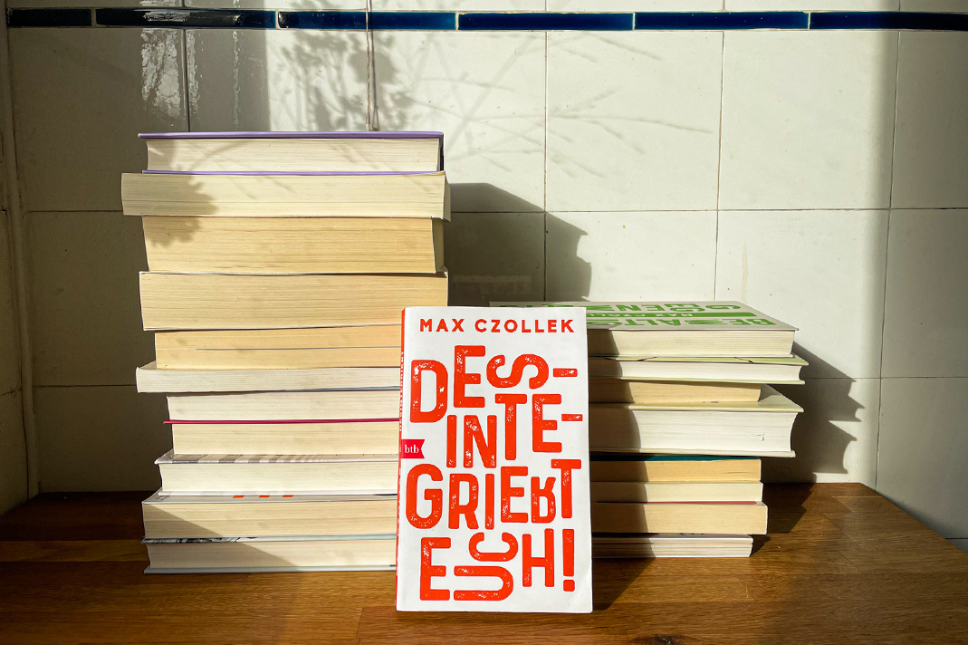 Bücherstapel, Desintegriert euch von Max Czollek im Vordergrund