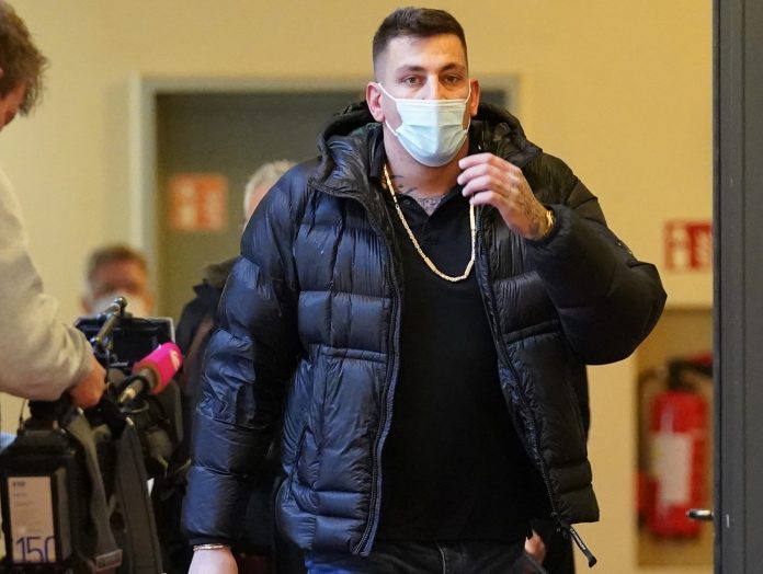 Der Rapper Gzuz betritt einen Gerichtssaal mit einem Mundschutz.