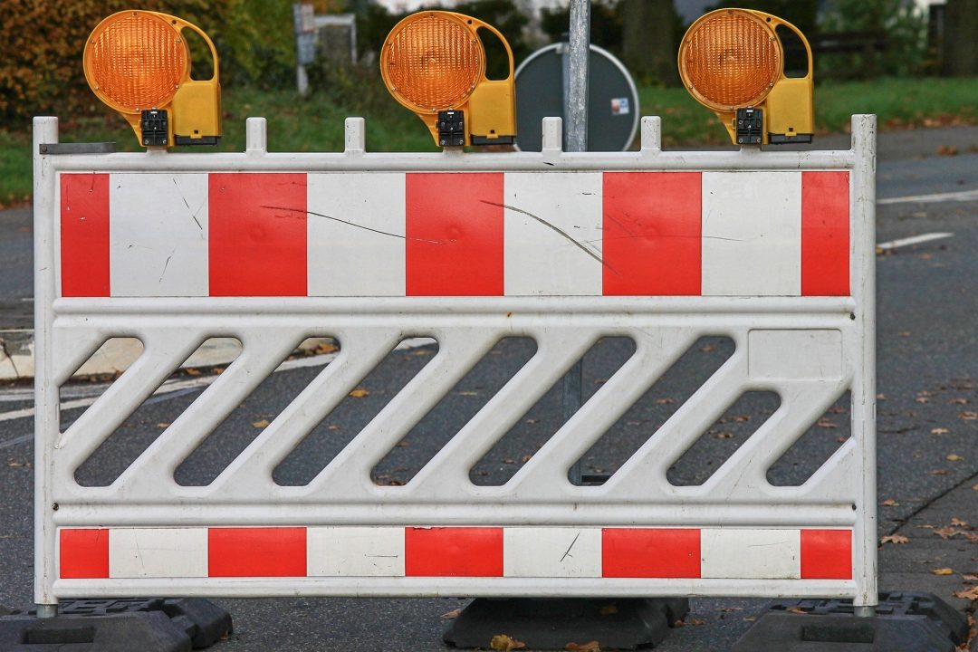 Eine Straßenabsperrung mit Warnleuchten steht auf einer Straße. Baustelle Elbchaussee, Bastelle, Sanierungsarbeiten, Stresemannstraße.