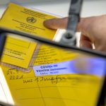 Gefälschte Impfpässe: Hamburger Polizei gründet Sonderkommission Abbildung einer aufgeschlagenen Impfpassfälschung und einer Lupe. Foto: Stefan Puchner/dpa.