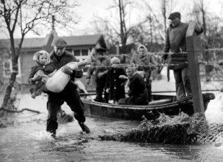 “Opa muss auch noch mit!”: 60 Jahre Sturmflut 1962 Sturmflut. Helfer retten eingeschlossene Bewohner:innen vor den Wassermassen.
