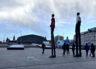 Eine Zukunft ohne Obdachlosigkeit: (K)eine Utopie Menschen versammeln sich unter den großen Figuren auf dem Arno-Schmidt-Platz beim Hambuger Hauptbahnhof