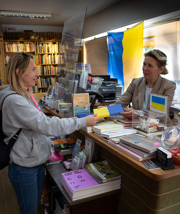 Natalia schenkt der Ukrainerin Hanna ein ukrainisches Kinderbuch. Foto: Laura Reichhart 