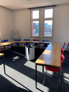 Die Sonne scheint in den Kursraum. Hier können die Teilnehmer in Hamburg Deutsch lernen. Die Tische bilden ein „U“. Noch sind die Plätze leer.