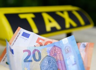Höhere Preise für Taxifahrten in Hamburg Taxifahren in Hamburg wird teurer. Geldscheine vor einem Taxi-Schild.
