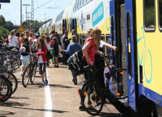 Fahrräder im Metronom. Menschen stehen am Bahnsteig mit ihren Fahrrädern und möchten in den Metronom einsteigen.