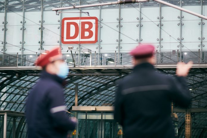 9-Euro-Ticket: Zwei Mitarbeiter der Deutschen Bahn stehen vor dem Hauptbahnhof.
