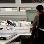 Zahl der Arbeitslosen in Hamburg steigt Arbeitslos Hamburg: Eine Frau mit dunklen Haaren sitzt an einem Schreibtisch und arbeitet am Computer. Auf dem Schreibtisch herrscht Chaos. Es liegen Papiere, Ordner und andere Arbeitsmaterialien herum.