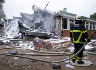 Explosion und Brand in Finkenwerder Schule Brand in Finkenwerder Schule: ein zerstörtes Verwaltungsgebäude mit Feuerwehrmann.
