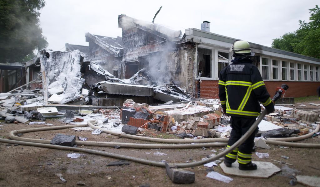 Brand in Finkenwerder Schule: ein zerstörtes Verwaltungsgebäude mit Feuerwehrmann.